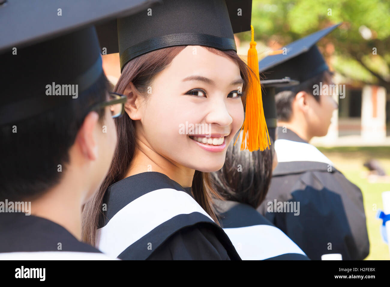 Woman standing out from a graduation group smiling Stock Photo - Alamy
