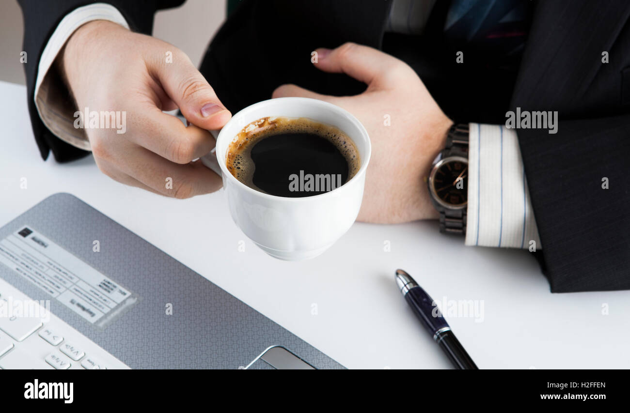 man holding the cup of coffee in the workplace Stock Photo - Alamy