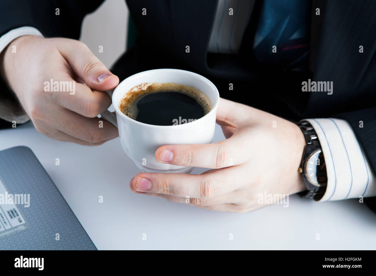 man holding the cup of coffee in the workplace Stock Photo - Alamy