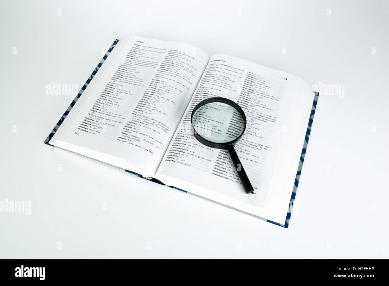 open book dictionary with loupe closeup Stock Photo Alamy
