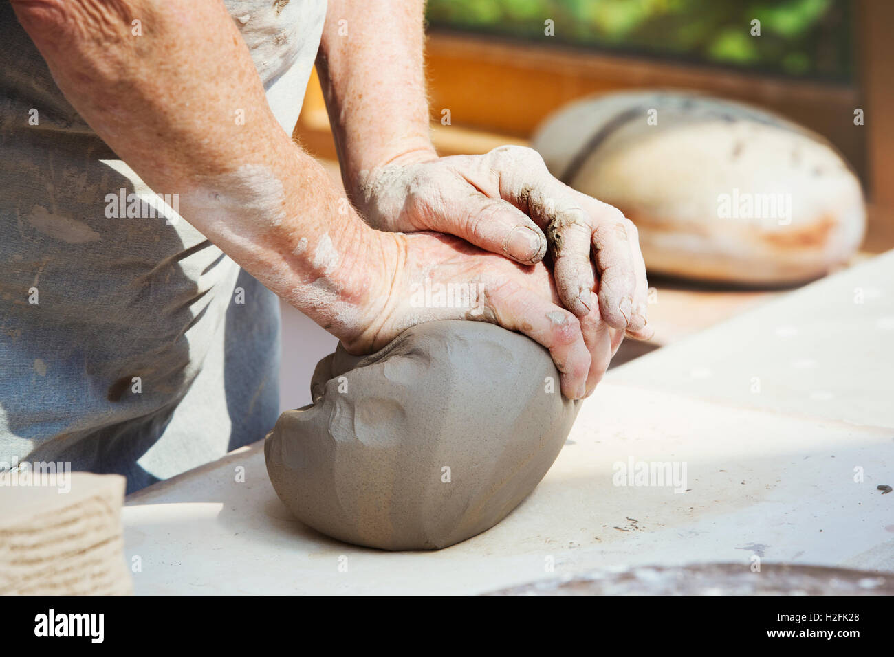 A person , potter preparing a lump of damp clay for throwing Stock
