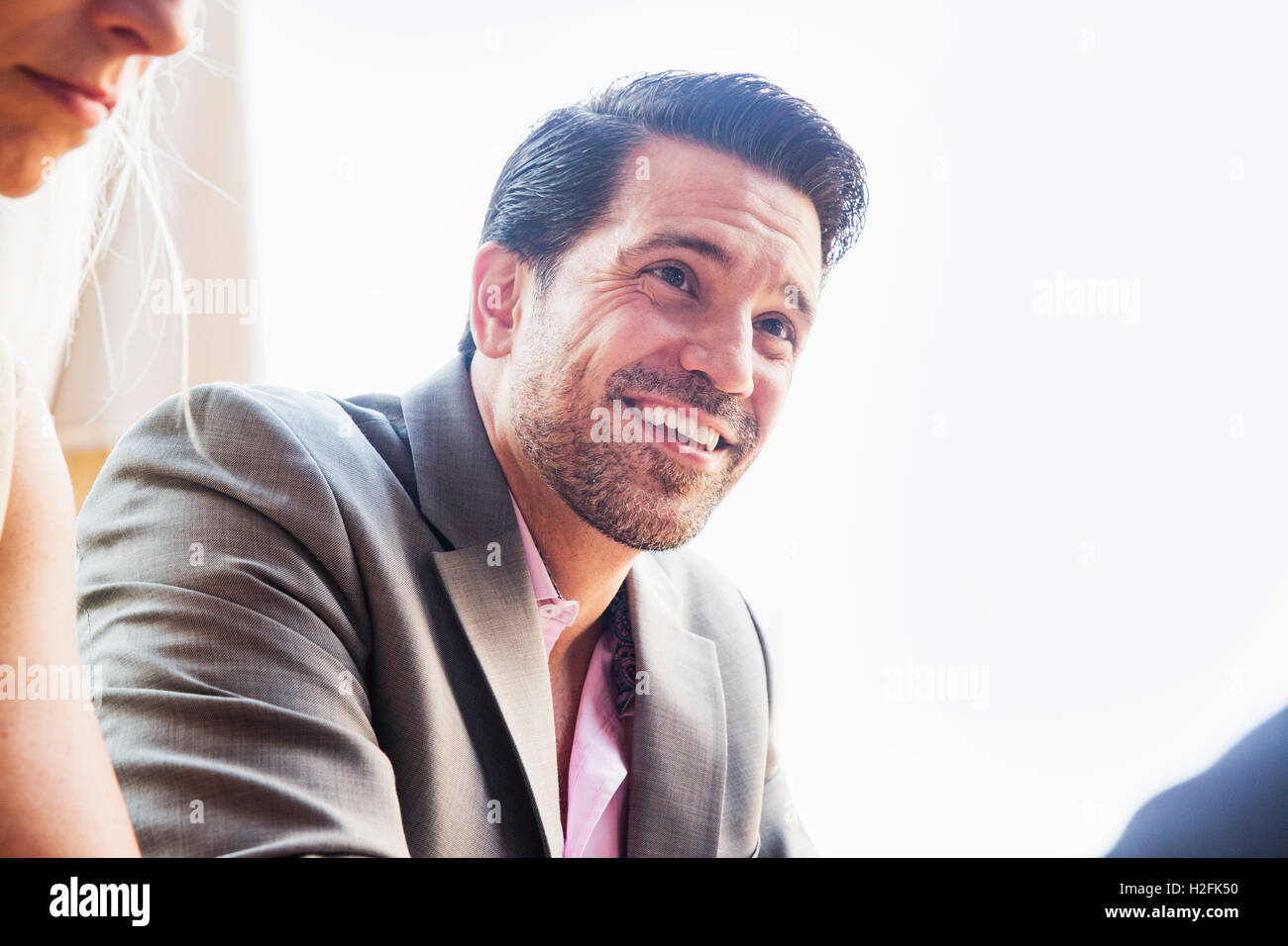 Smiling businessman wearing a grey suit and pink shirt Stock Photo - Alamy