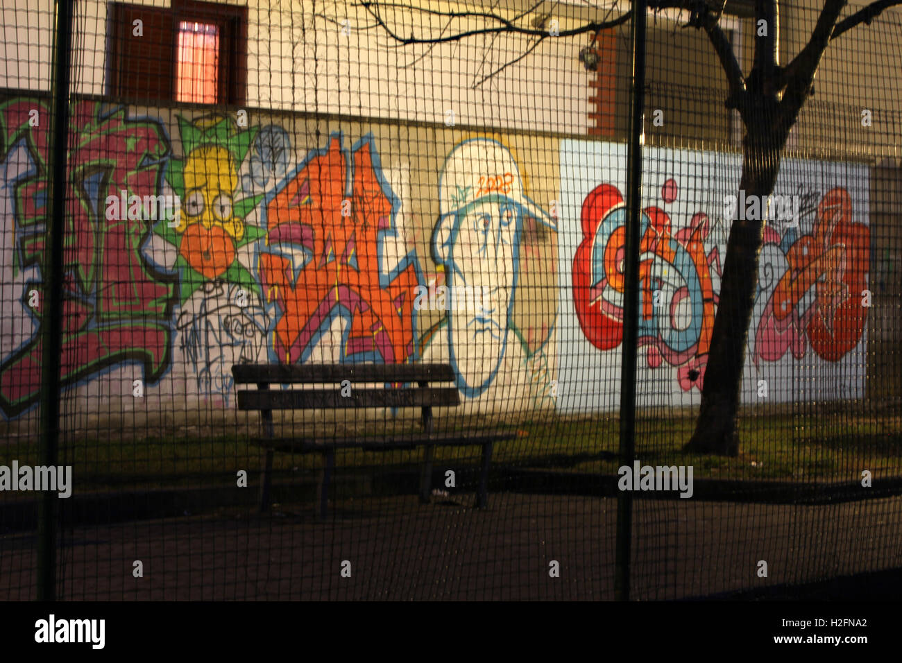 Graffiti, aerosol art in park at night through a fence Stock Photo