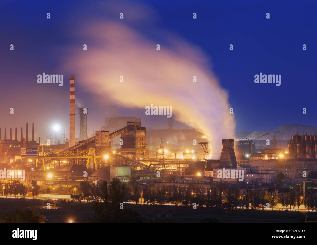 Metallurgical plant at night. Steel factory with smokestacks. Steelworks, iron works. Heavy industry in Europe. Air pollution fr Stock Photo