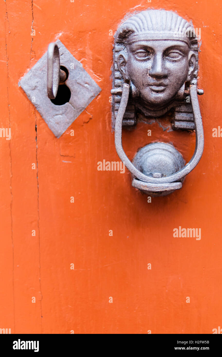 Head of the Sphinx with iron knocker on old door in orange wood. Lock and key. Alchemy, mystery Stock Photo