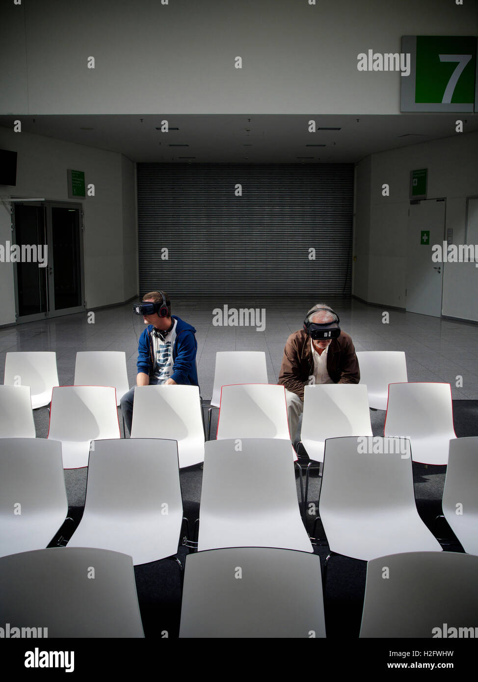 The future of visual entertainment, two men wearing VR glasses in boring and sterile environment. Cologne, Germany Stock Photo