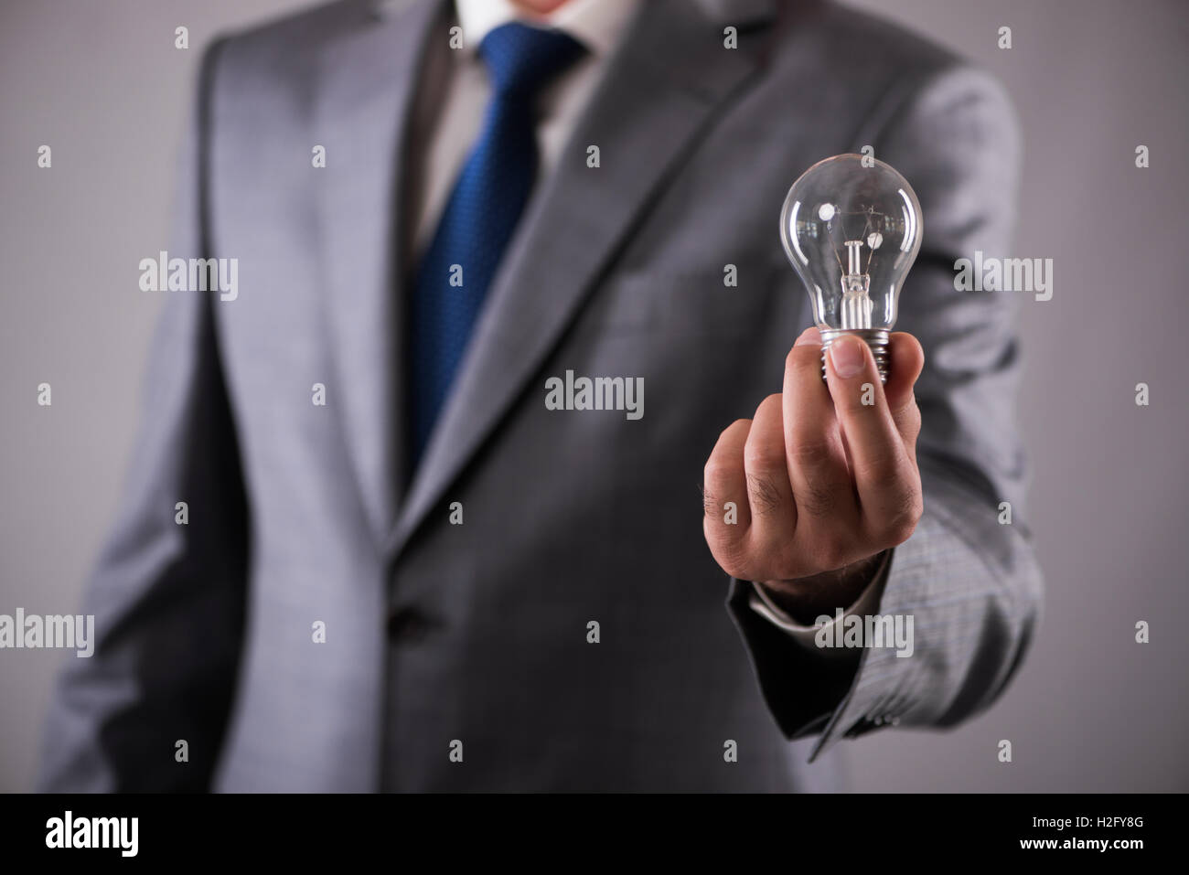 Businessman holding light bulb in creativity concept Stock Photo - Alamy