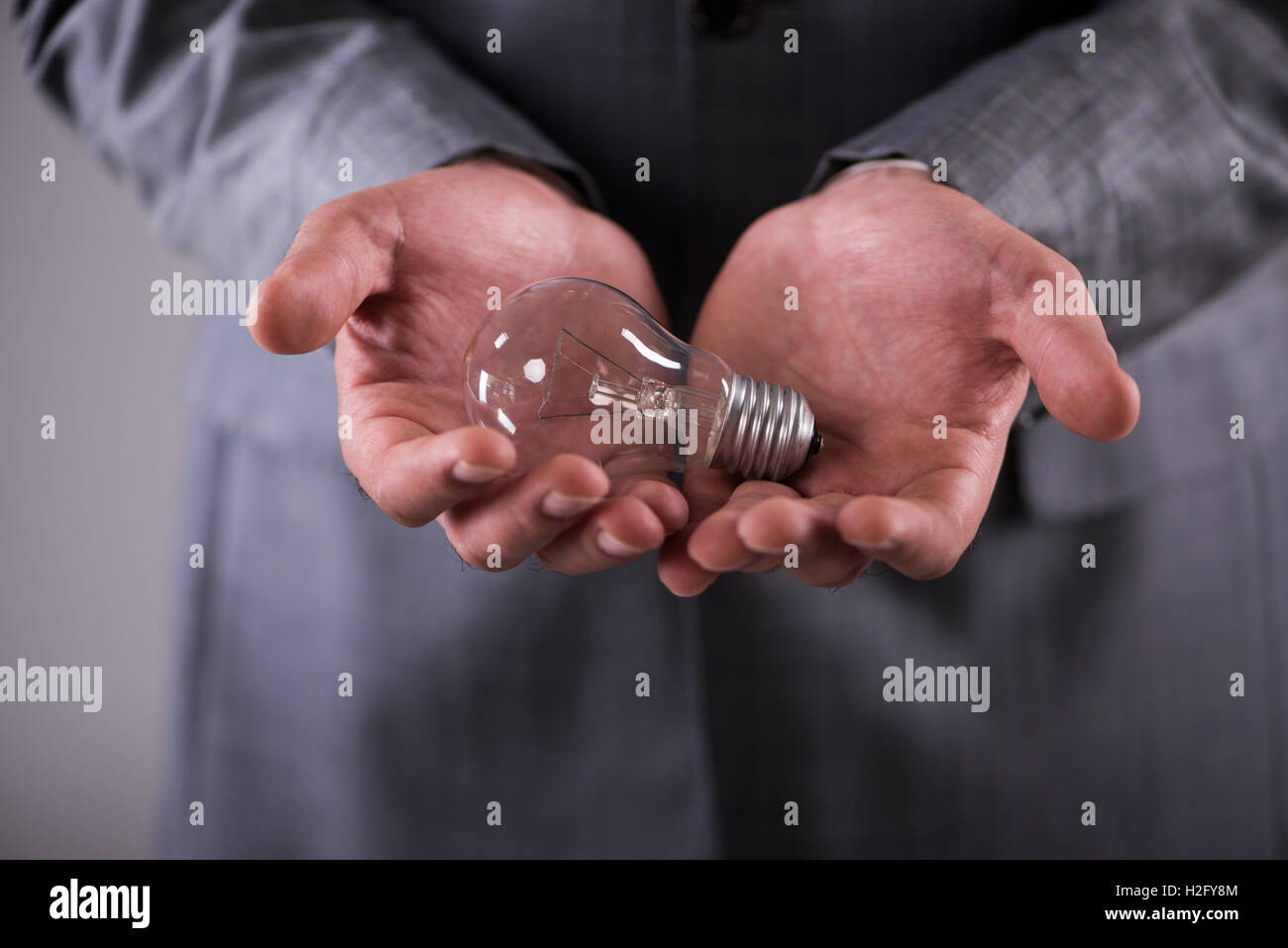 Businessman holding light bulb in creativity concept Stock Photo - Alamy