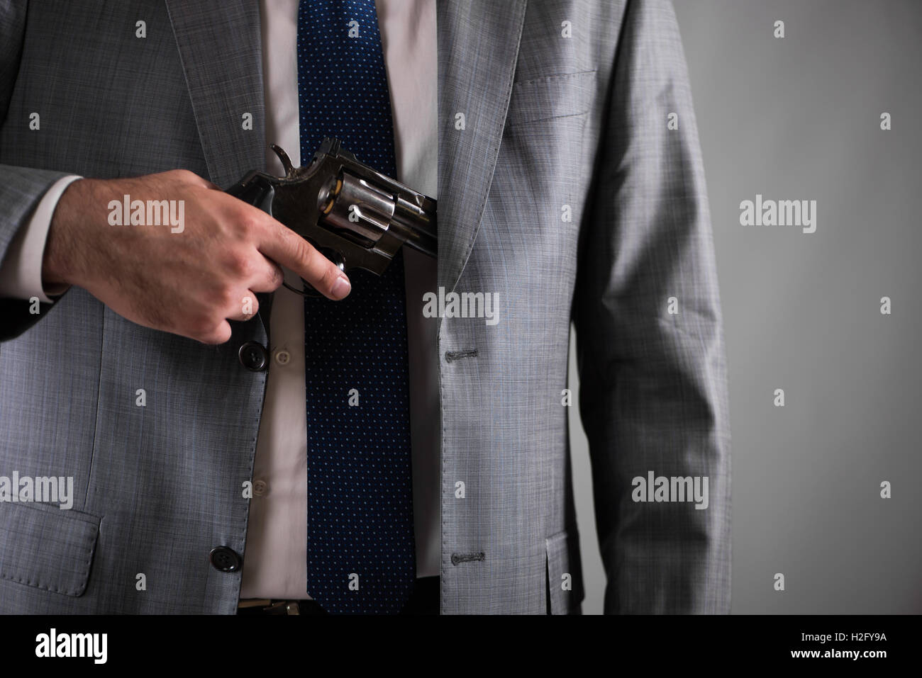 Man pulling out gun from his pocket Stock Photo - Alamy