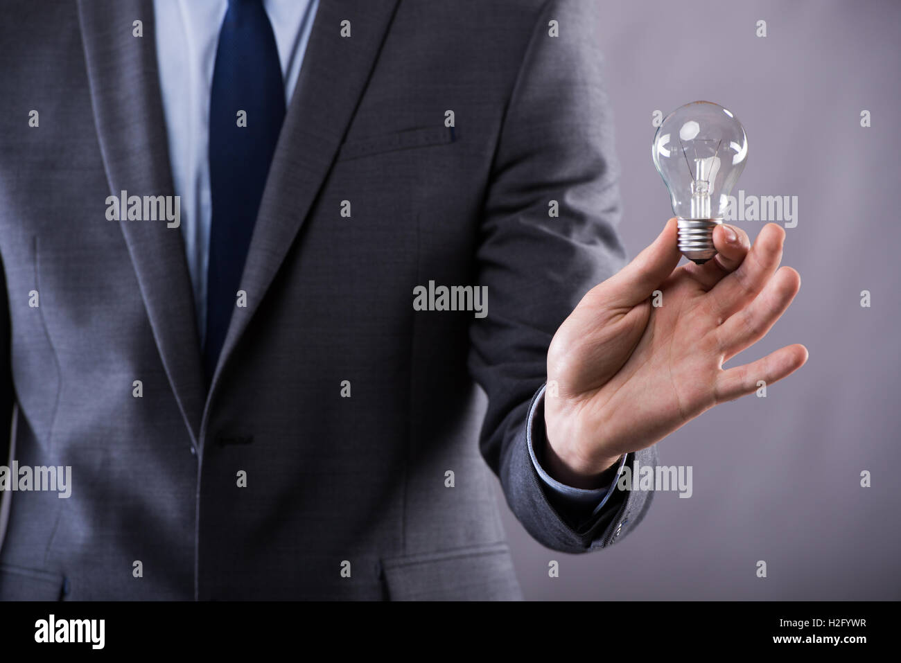 Businessman holding light bulb in creativity concept Stock Photo - Alamy