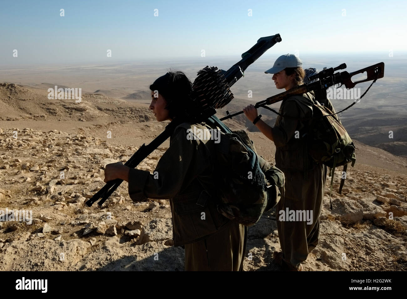A group of female Kurdish fighters of the Free Women's Units shortened as YJA STAR the women's military wing of the Kurdistan Workers' Party PKK walking heavily armed in a mountainous area in the countryside of Makhmur near Mosul Northern Iraq Stock Photo