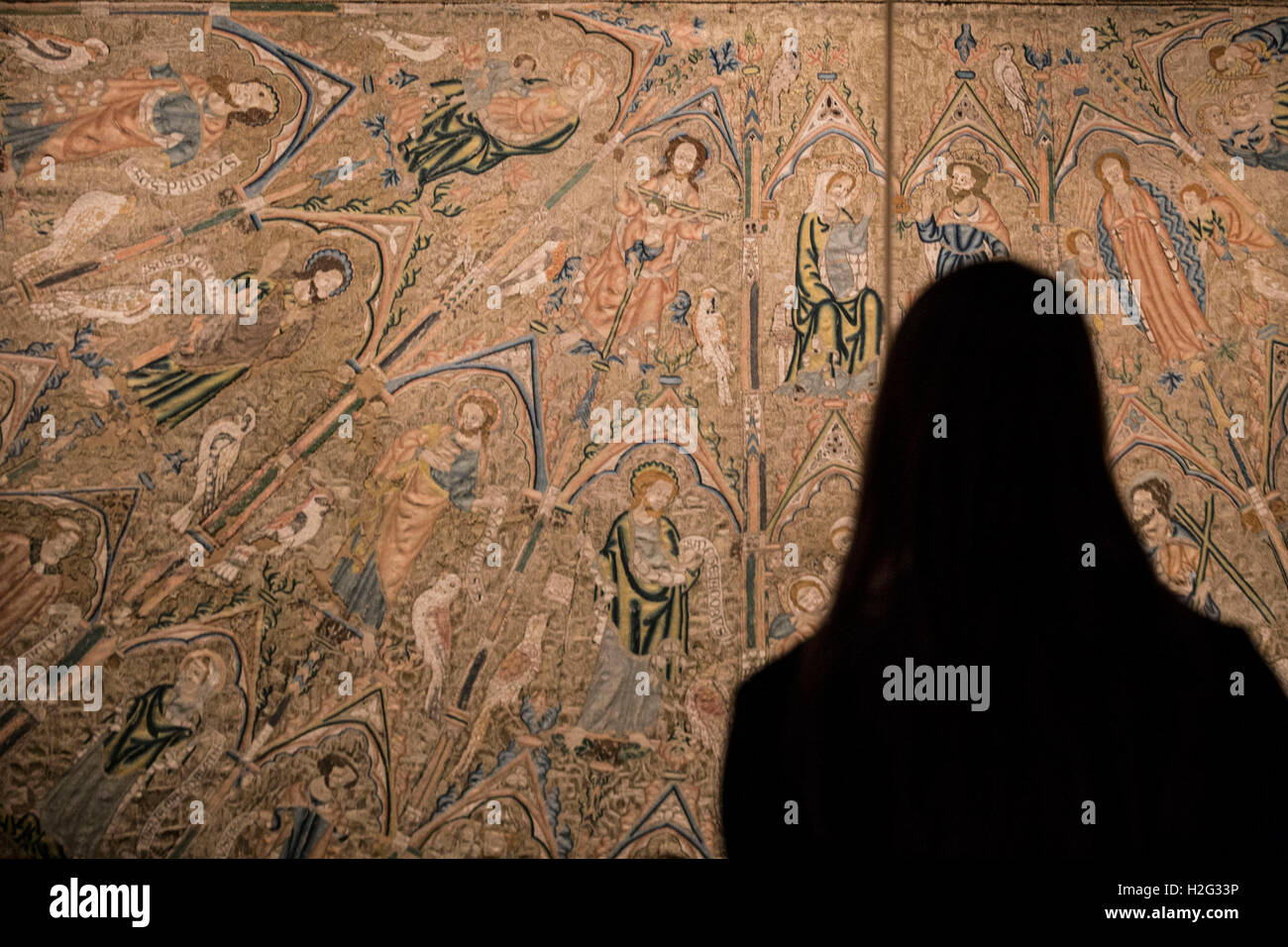 A woman looks at embroidery on display as part of the Opus Anglicanum