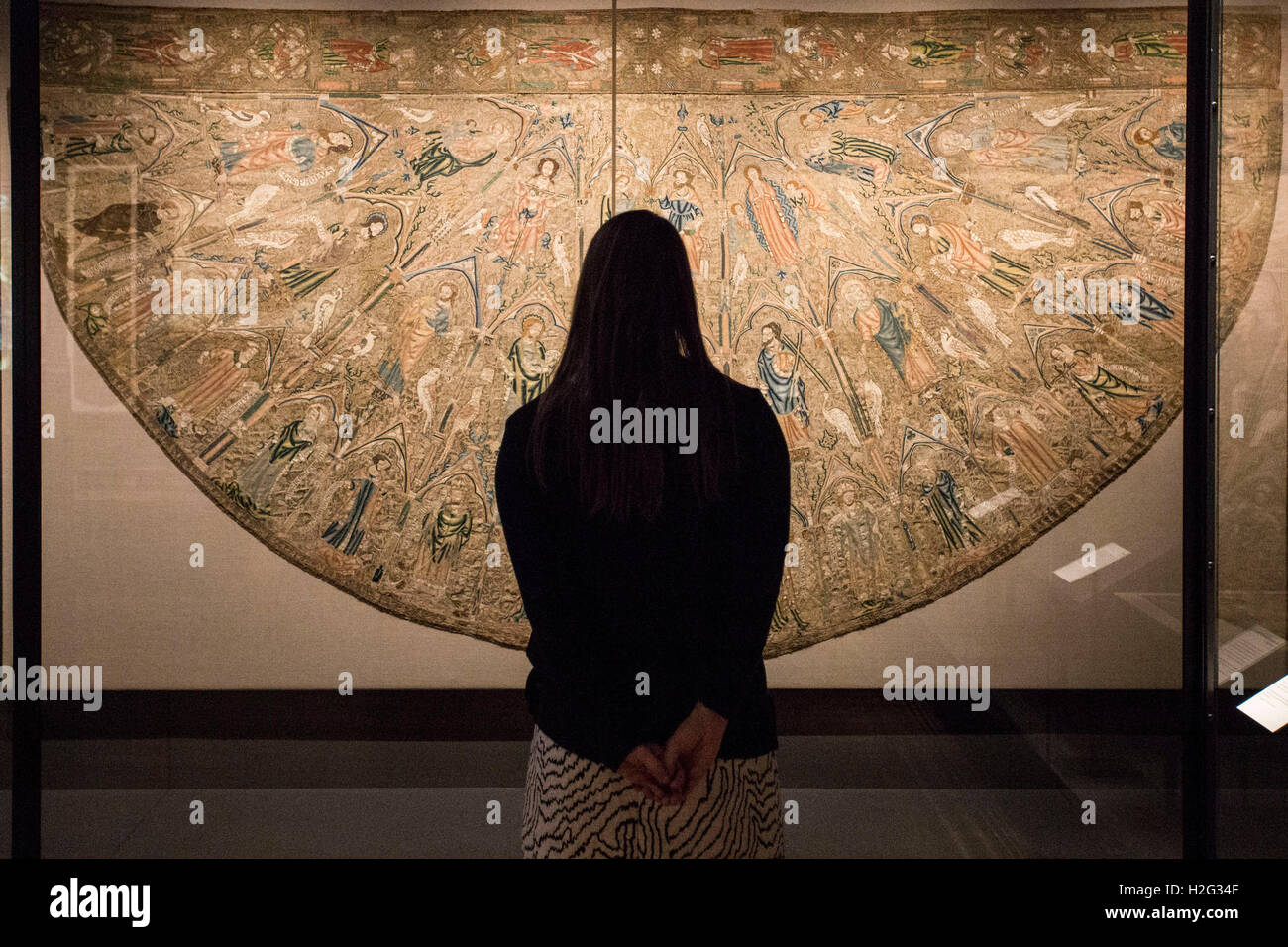A woman looks at embroidery on display as part of the Opus Anglicanum