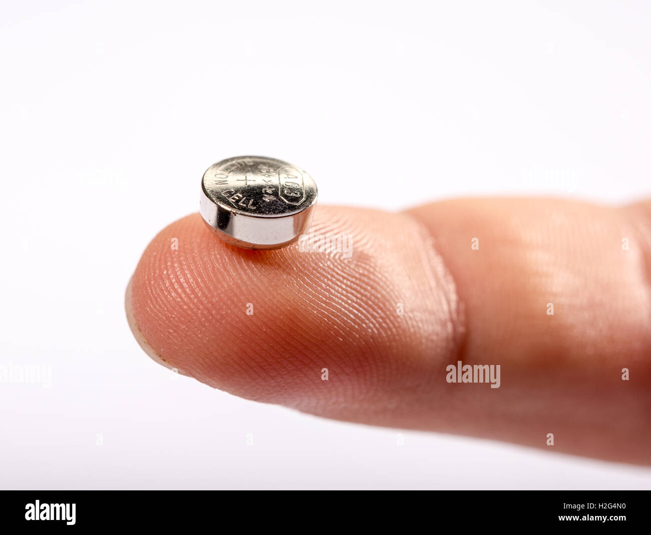 A child holding a button cell battery Stock Photo