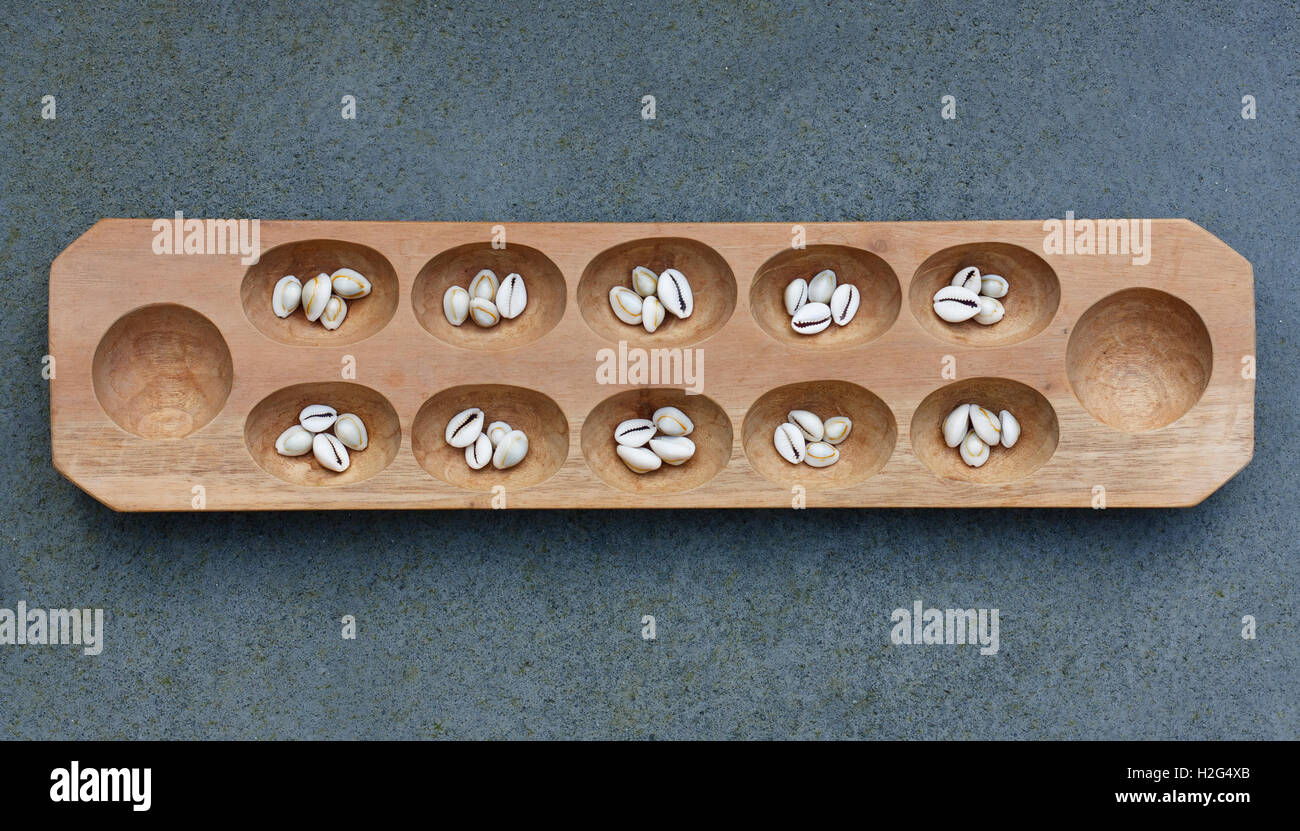 Mancala board with shells. Mancala is a traditional board game played around the world. Stock Photo
