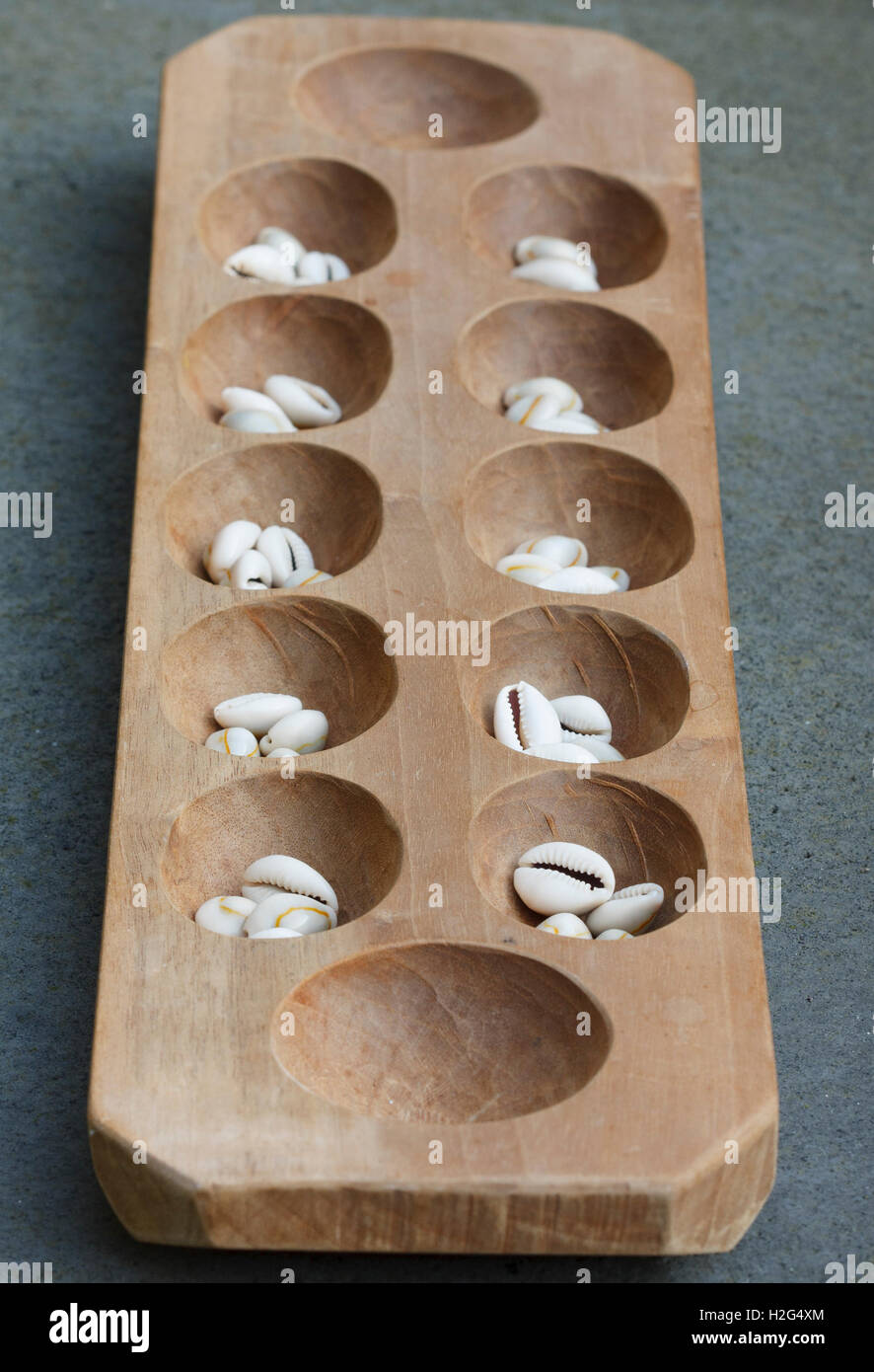Mancala board with shells. Mancala is a traditional board game played around the world. Stock Photo