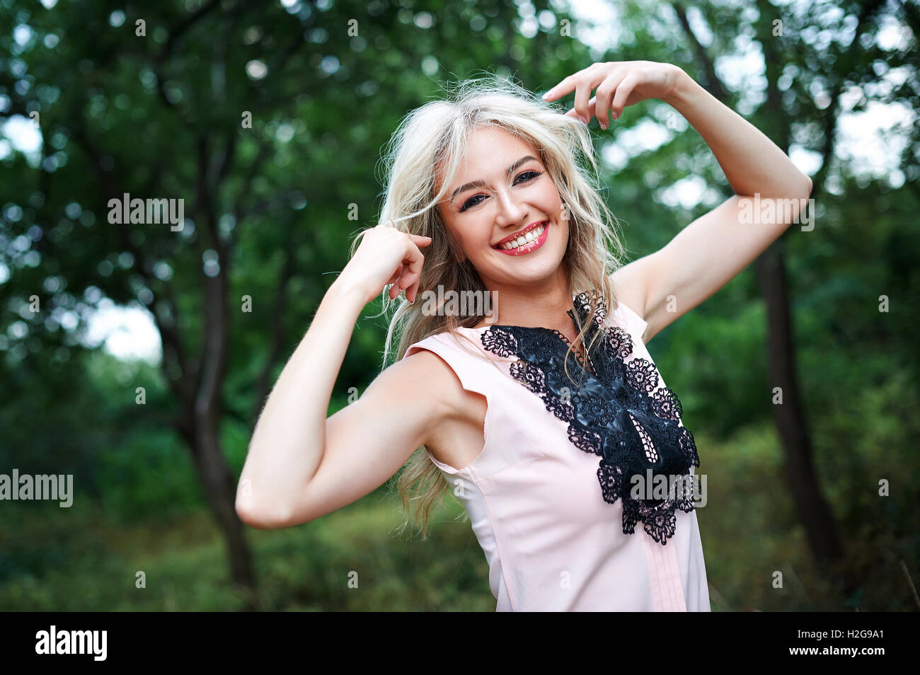 woman with long blond hair posing in summer park Stock Photo