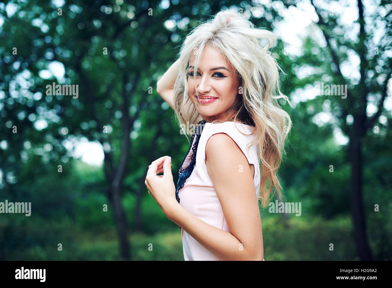 woman with long blond hair posing in summer park Stock Photo