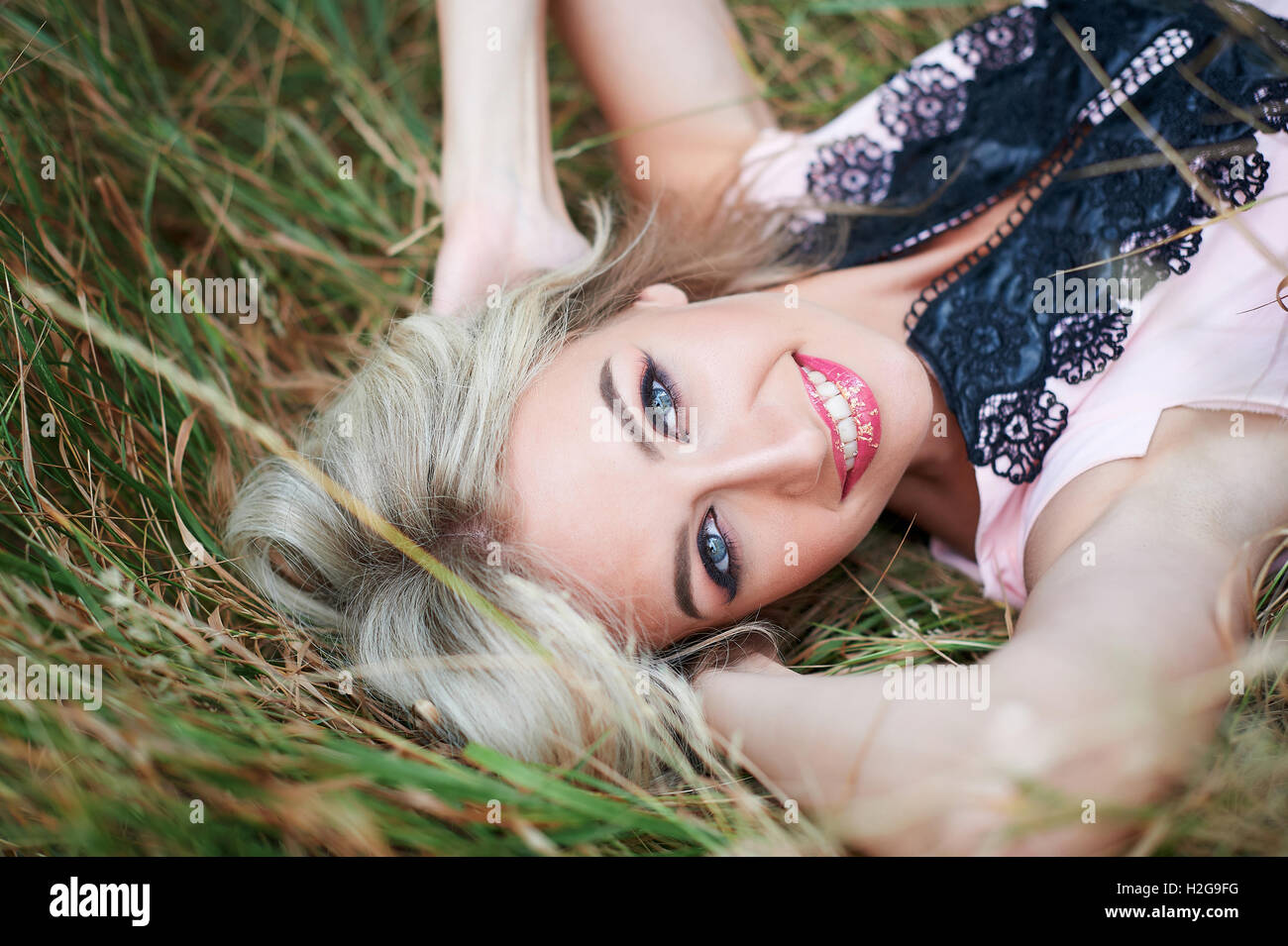 Young happy woman lying on the grass Outdoors Stock Photo