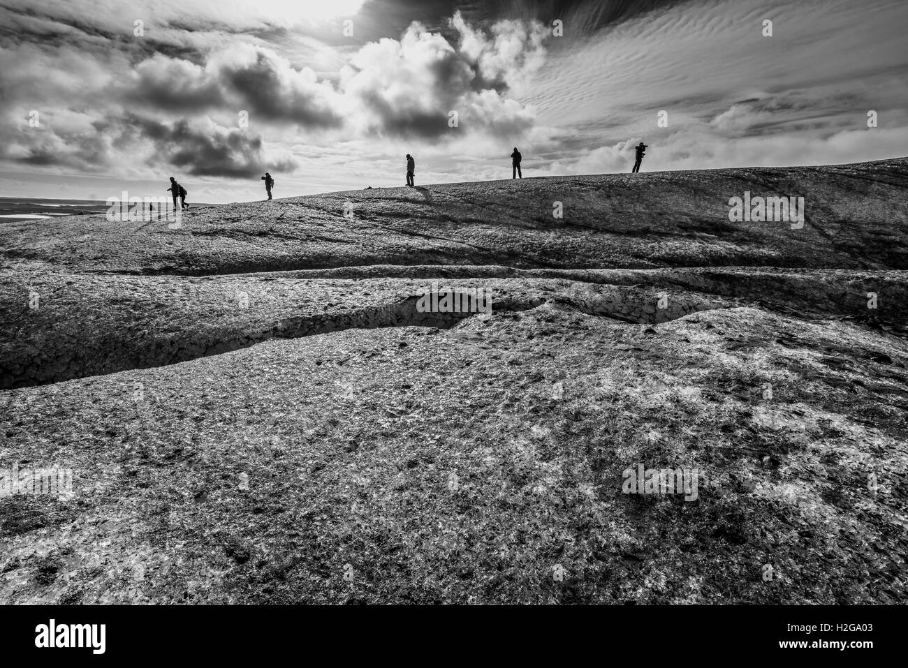 People hiking by the crevasses in the ice, Breidamerkurjokull glacier, Vatnajokull Ice Cap, Iceland. Stock Photo