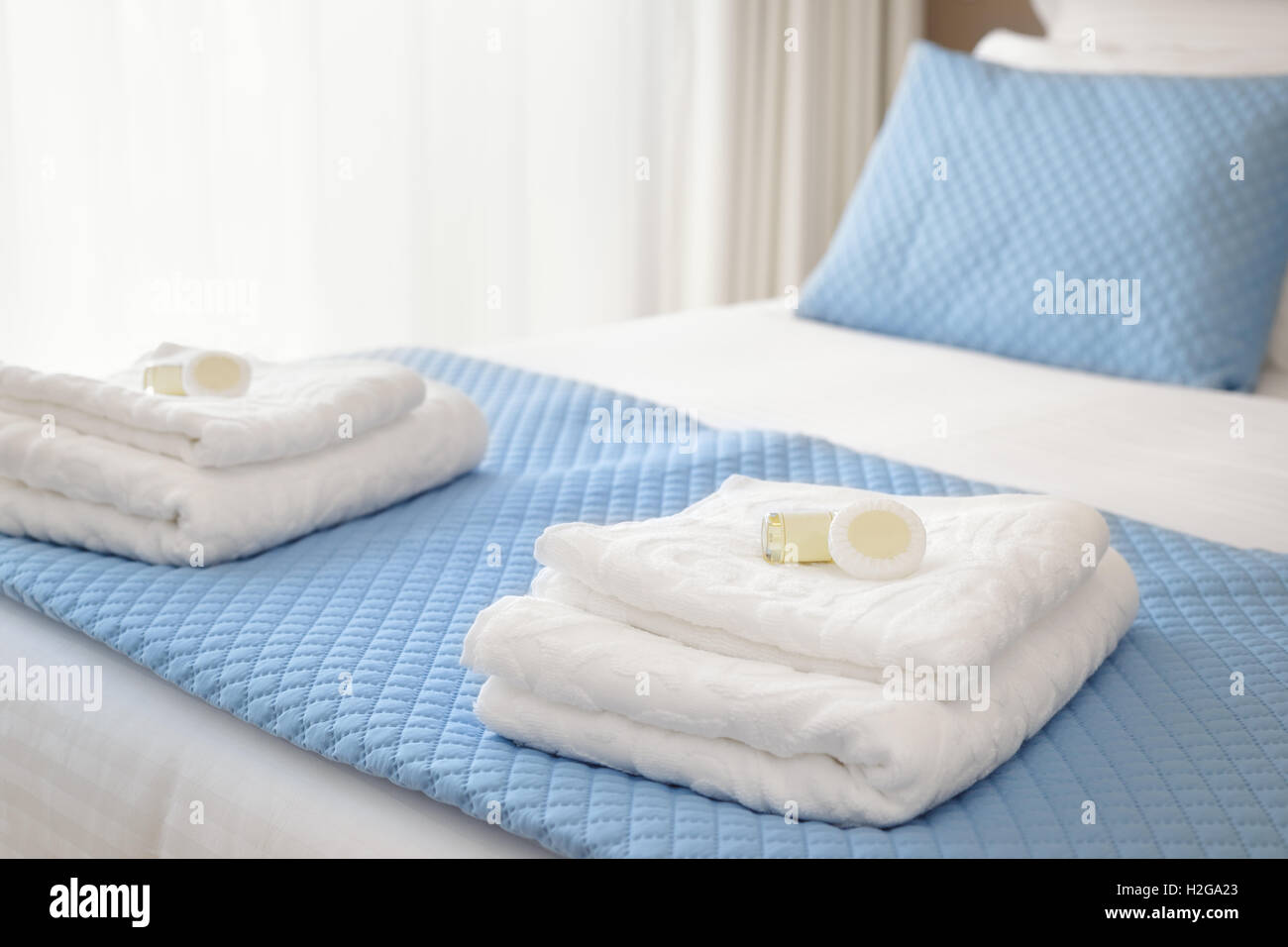 Bed with fresh towels and amenities Stock Photo