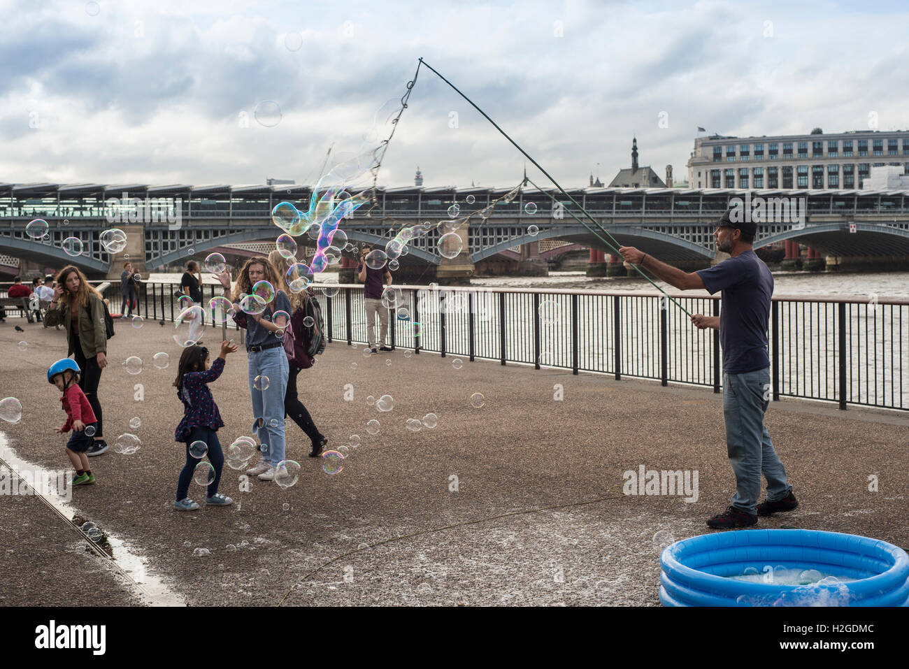 Street entertainer on London's Southbank blowing bubbles for children Stock Photo
