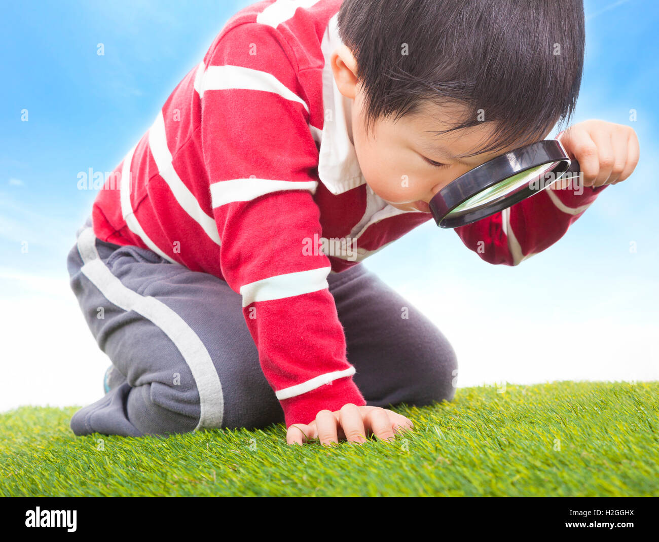 a boy exploring nature with magnifying glass Stock Photo - Alamy