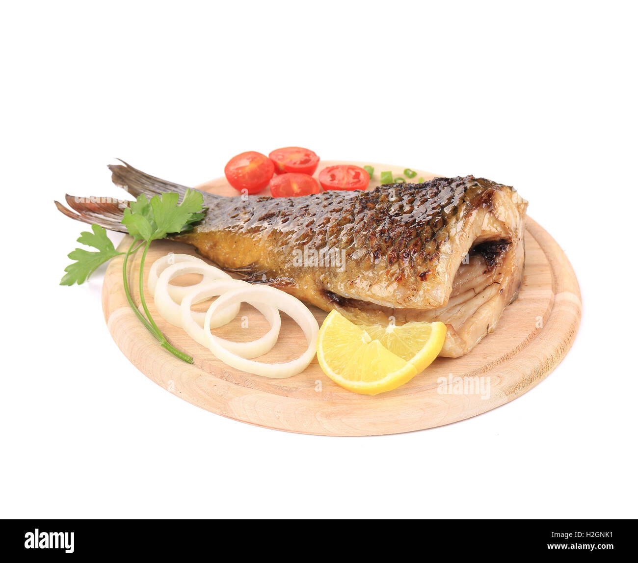 Fried carp tail with lemon and cherry tomatoes. Stock Photo