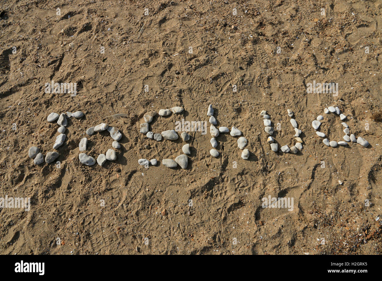 Name, Joshua, written in pebbles on a sandy beach Stock Photo