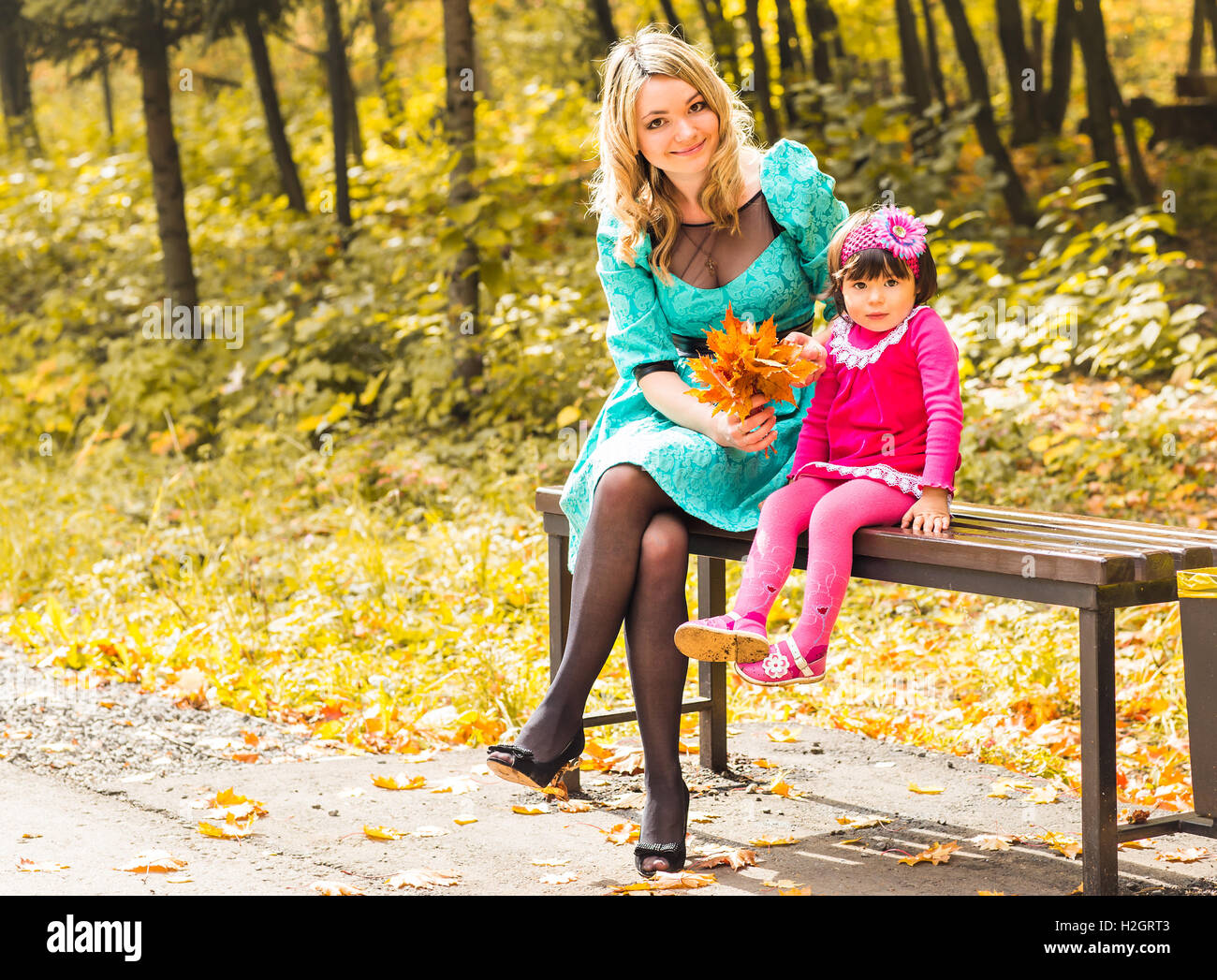 Little girl and her mother playing in the autumn park Stock Photo - Alamy