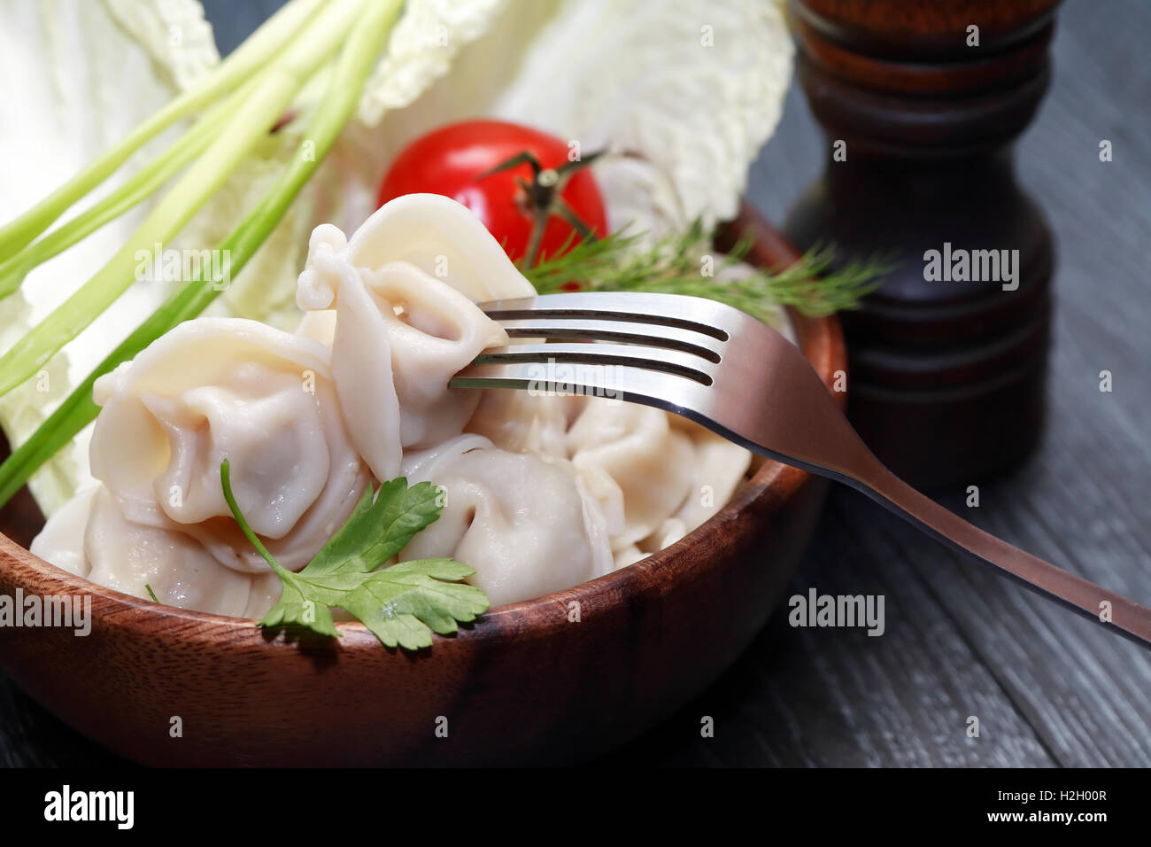 Dish with ravioli with fork. Also tomato and salad Stock Photo
