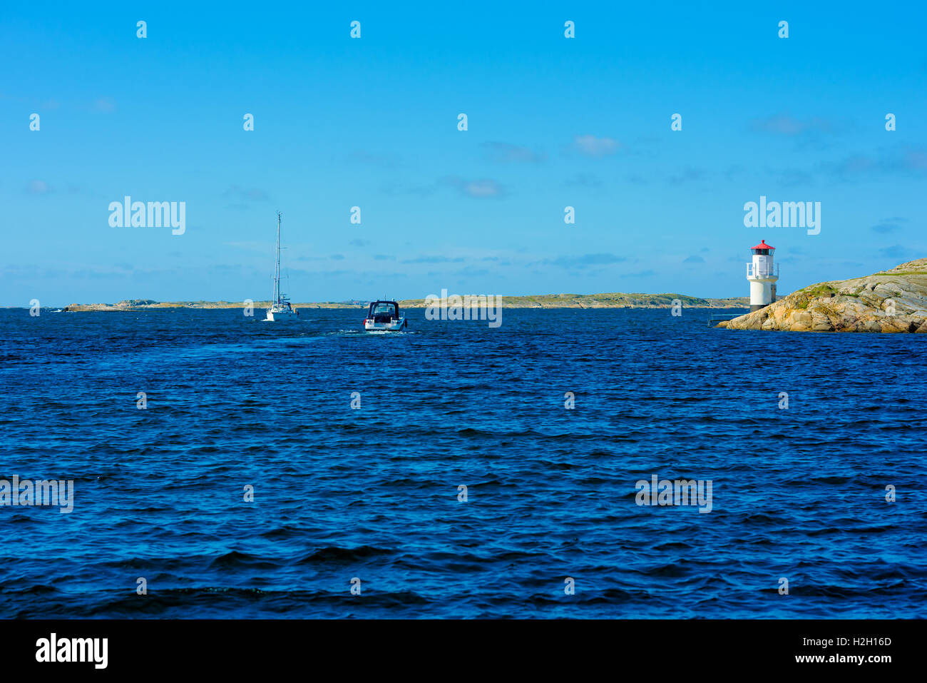 Mollosund, Sweden - September 9, 2016: Travel documentary of two boats meeting in the waterway beside the lighthouse. Stock Photo