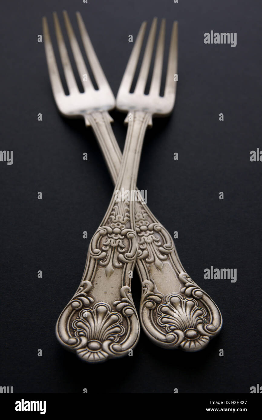 Antique silver forks on a black background with shallow focus Stock