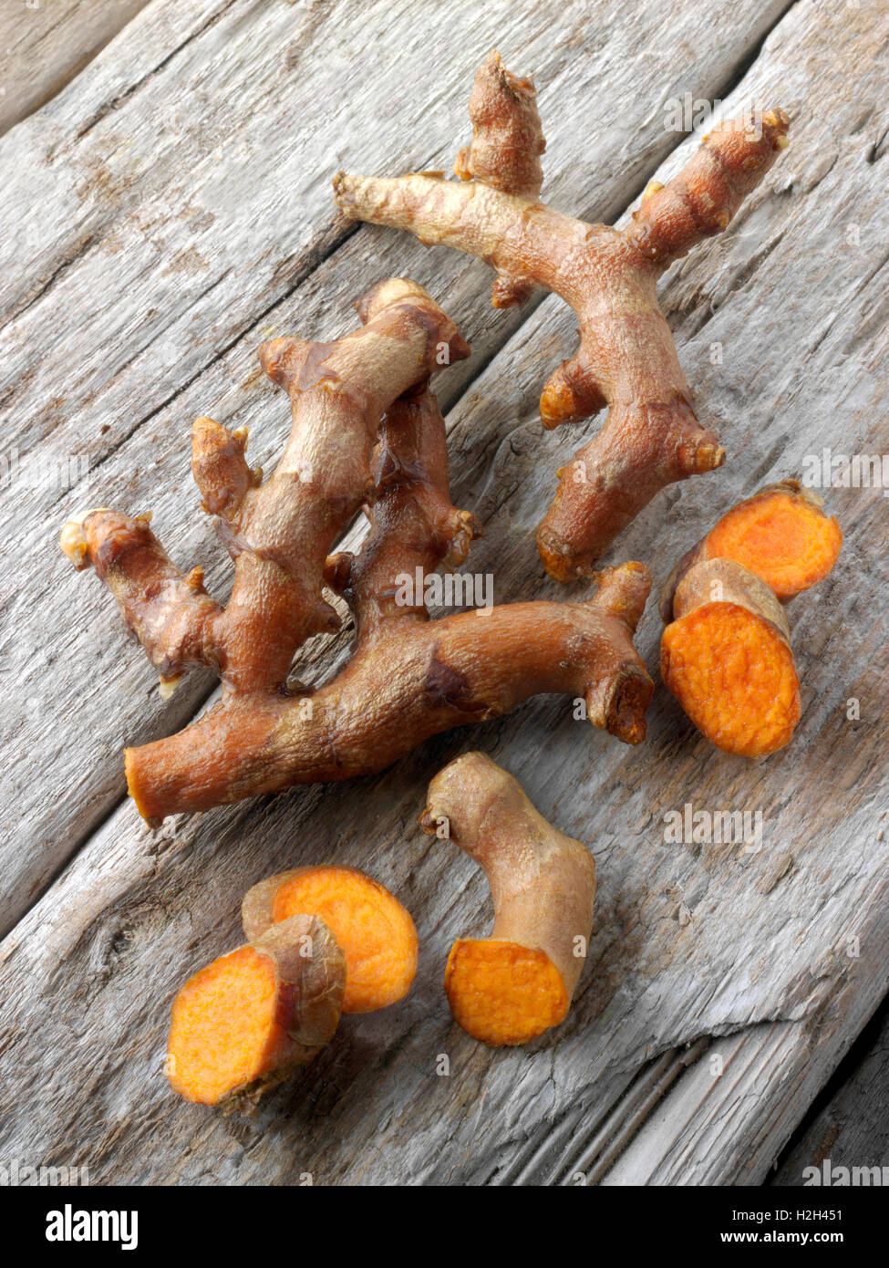 Fresh whole and cut turmeric or tumeric root (Curcuma longa) Stock Photo