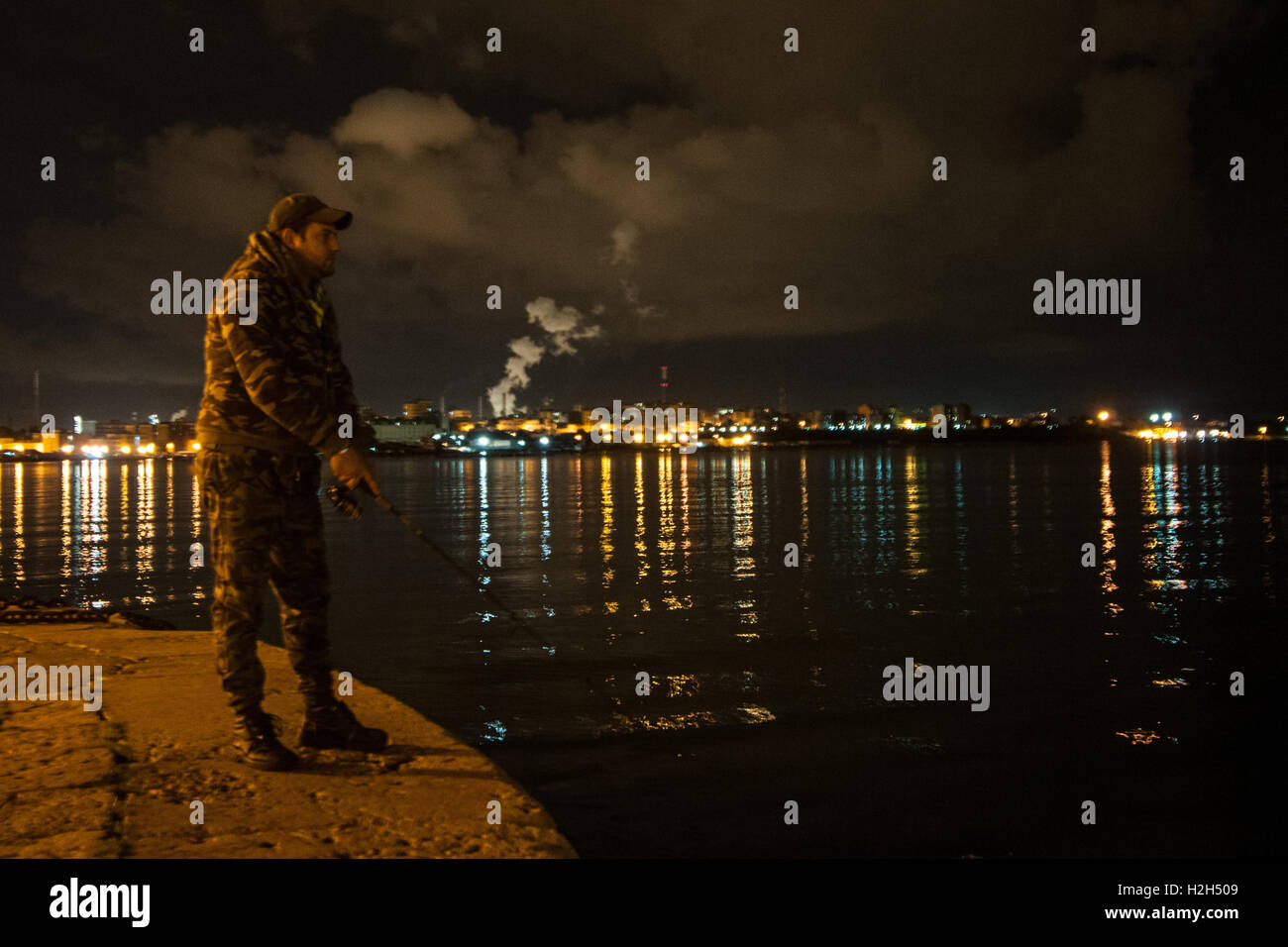 Citizen of Taranto fishing with the pollution on the background, south of Italy. Stock Photo