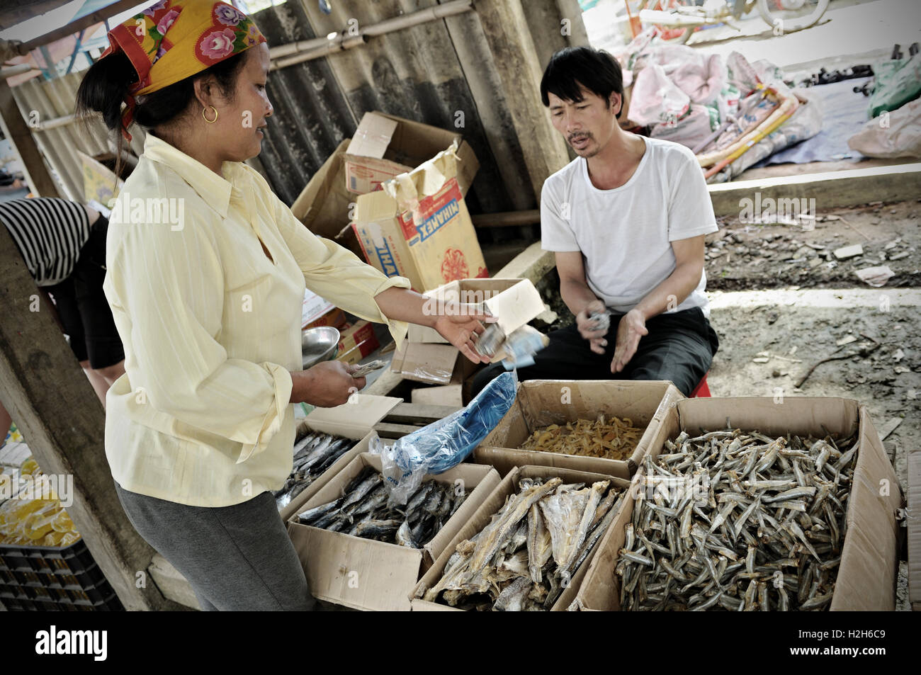 Man selling dried fish at the Quyet Tien market in Ha Giang Province, North Vietnam Stock Photo