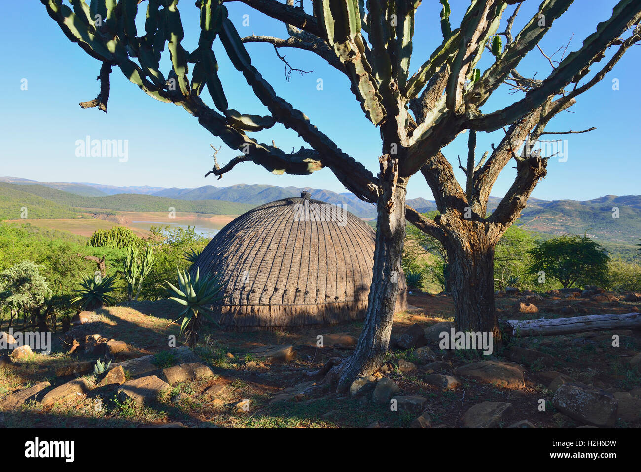 A traditional Zulu round beehive hut overlooking the Phobane Lake in  the   Shakaland Cultural Village near Durban South Africa Stock Photo