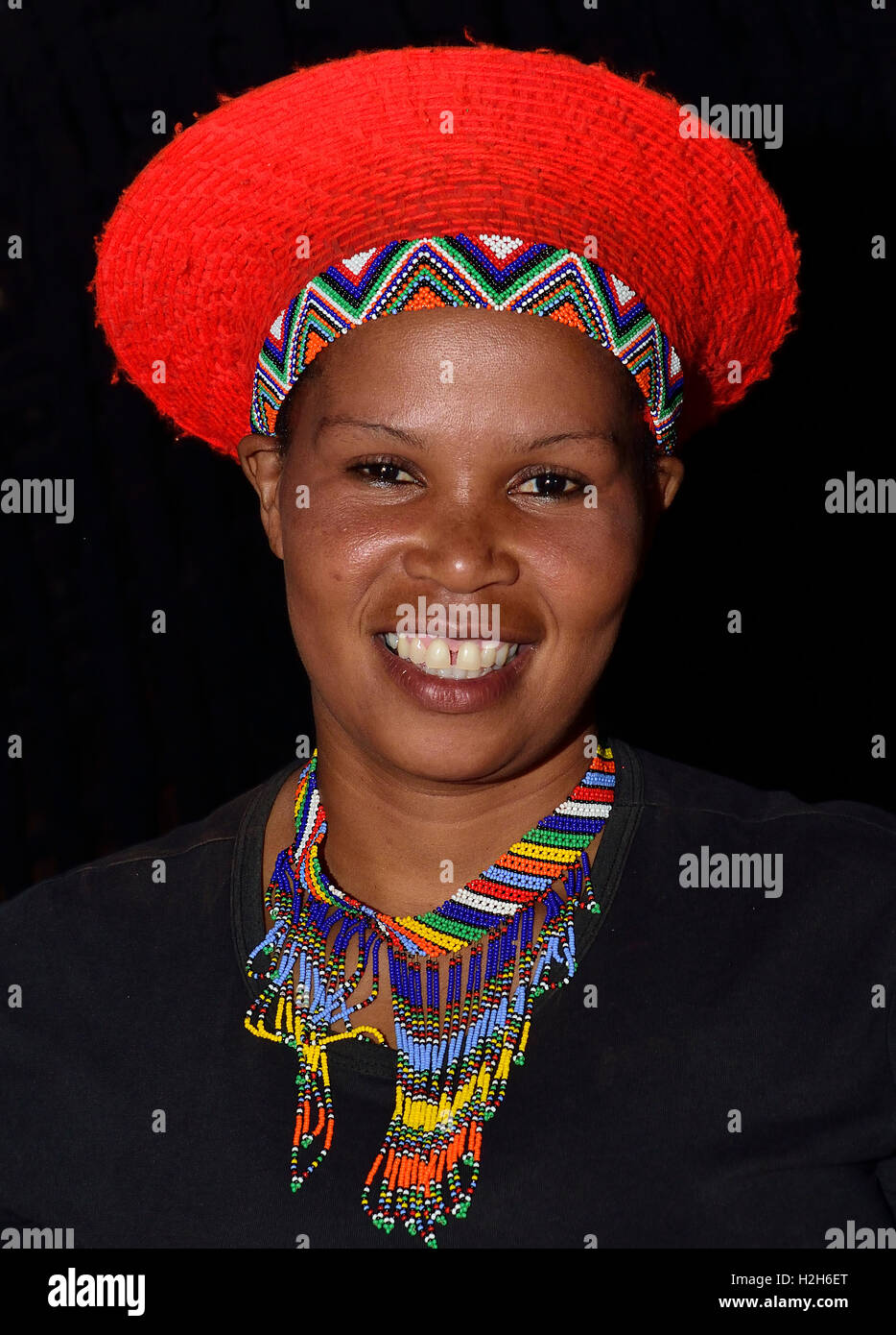 Shakaland Zulu girl in  a traditional Zulu hat  poses for the camera  at the Shakaland Cultural Village, Stock Photo