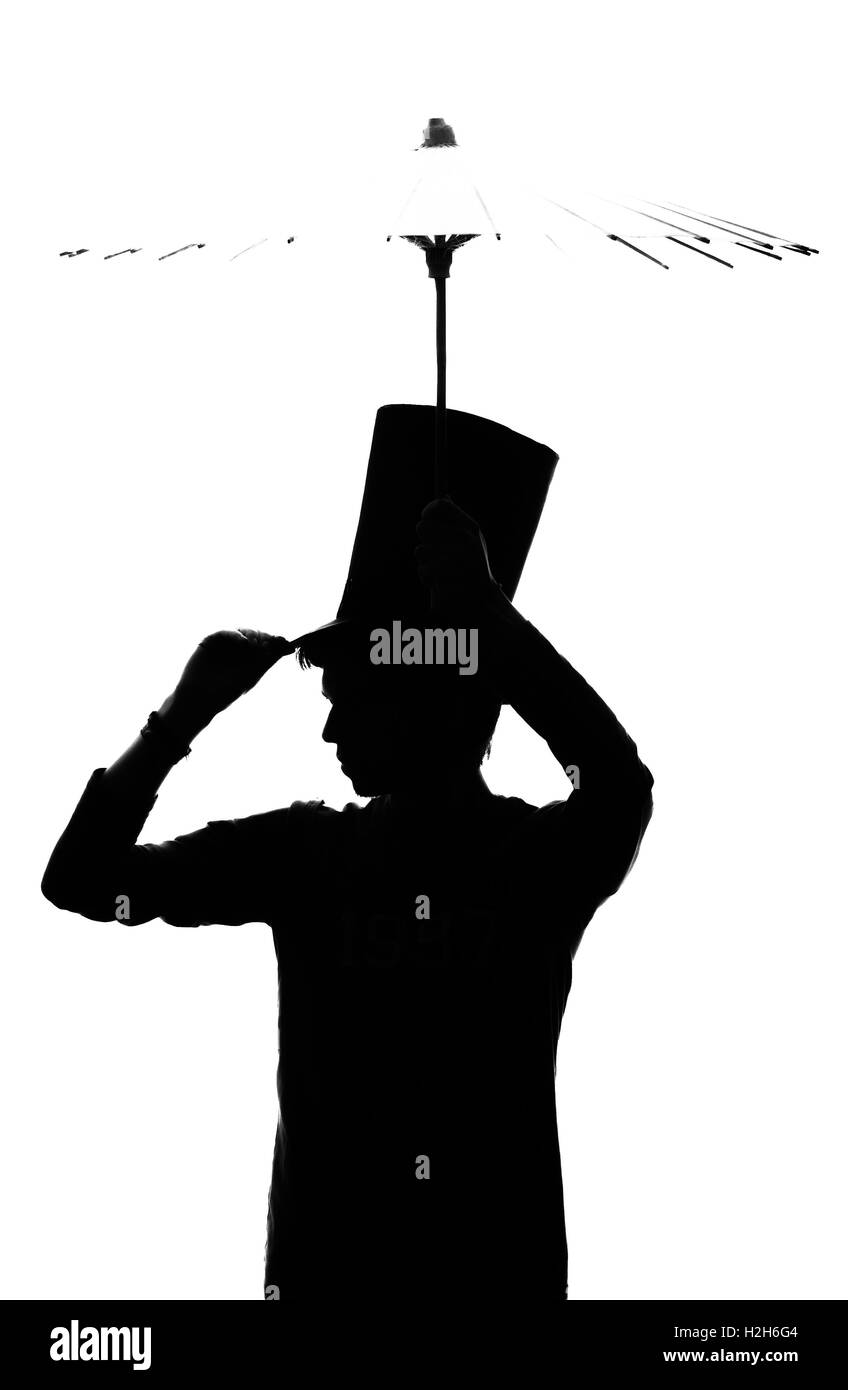 Silhouette of a man in a hat with an umbrella. Stock Photo