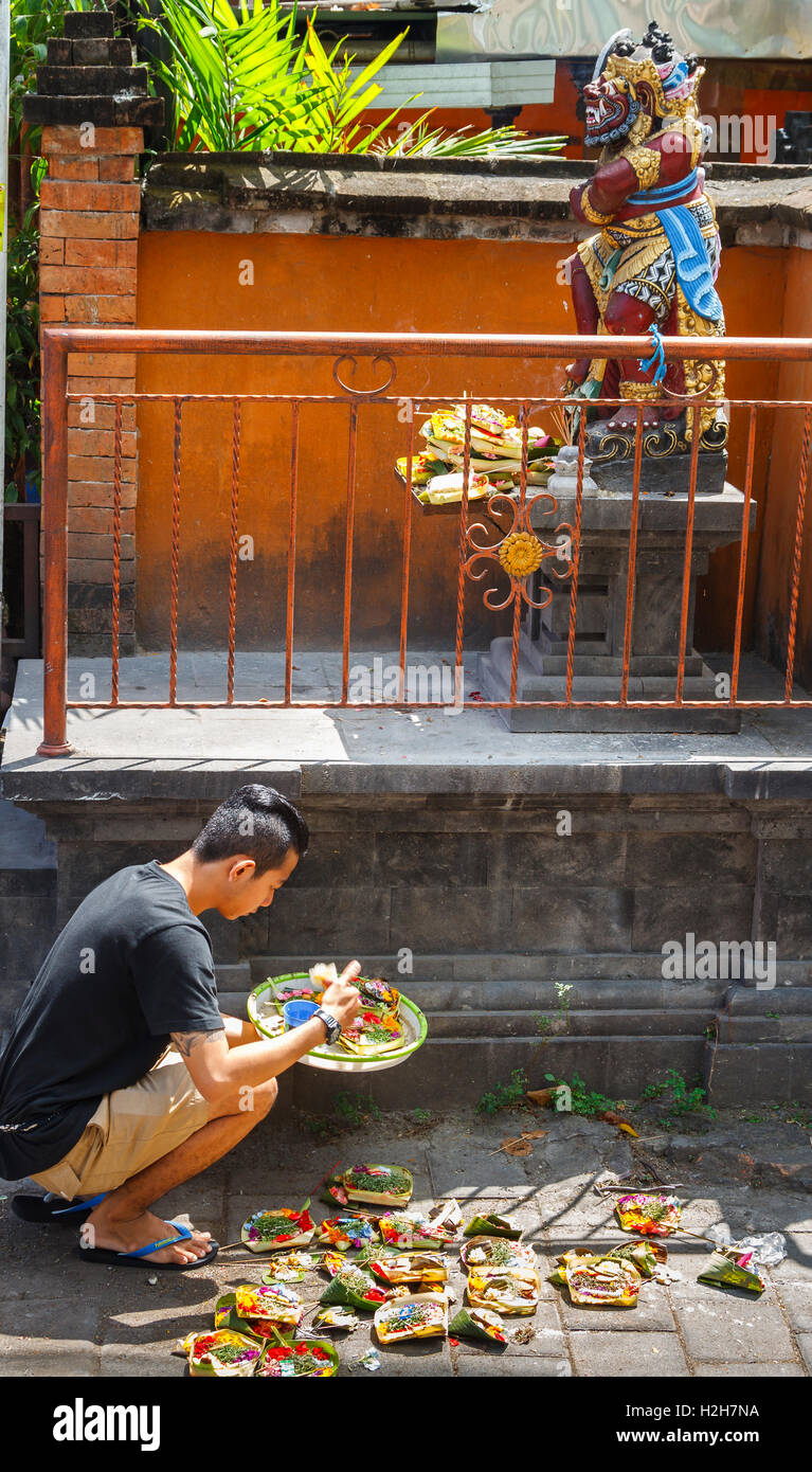 Religious image and young men with offering in the street. Stock Photo
