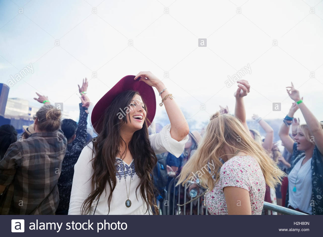 Smiling young women dancing in crowd at summer music festival Stock ...