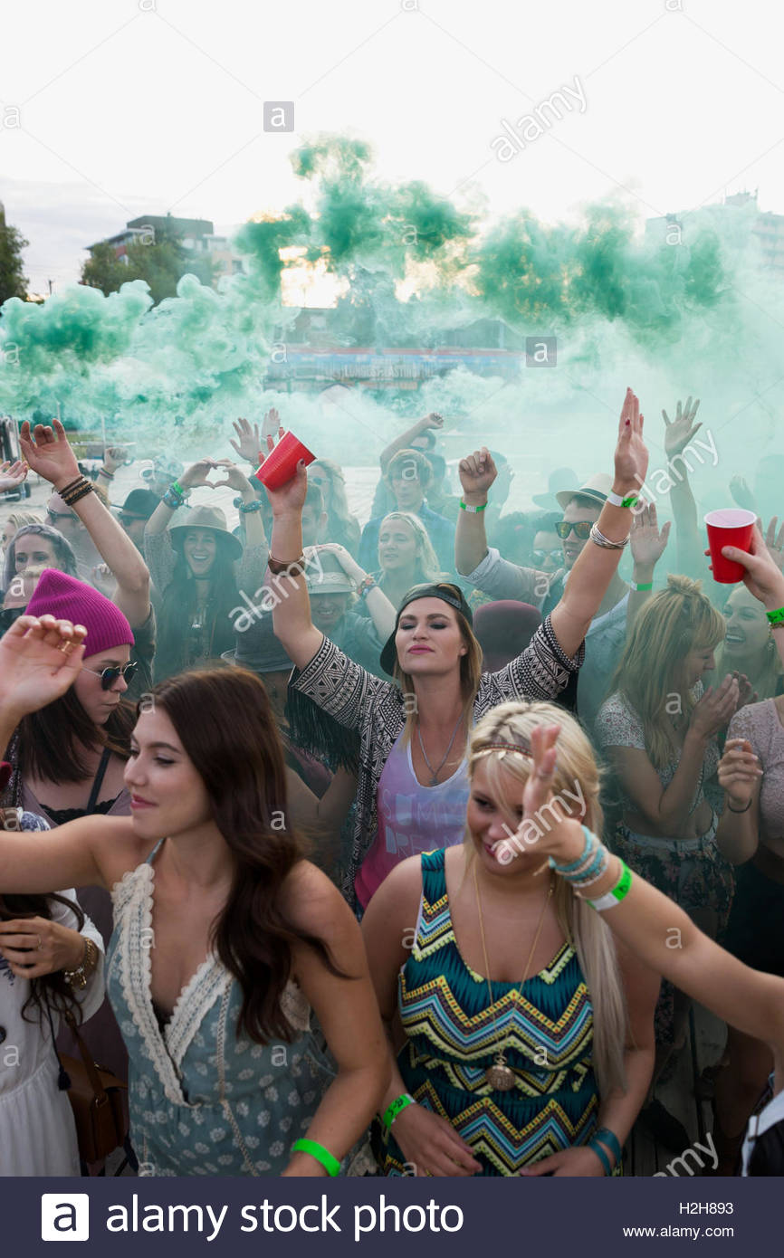 Young women cheering in powder crowd at summer music festival Stock Photo