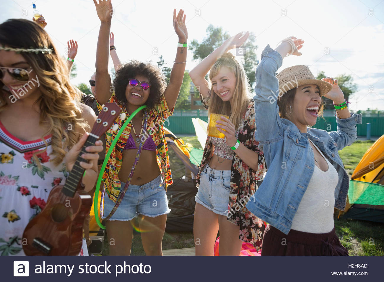 Enthusiastic young women dancing at summer music festival Stock Photo