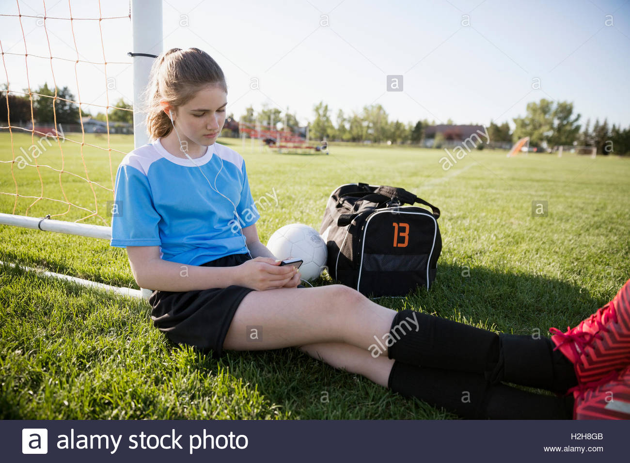 Middle school girl soccer player listening to music with headphones and