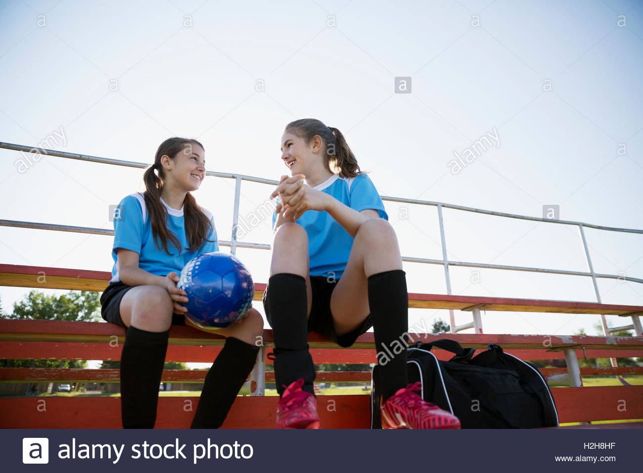 middle school girl soccer teammates talking on bleachers Stock Photo