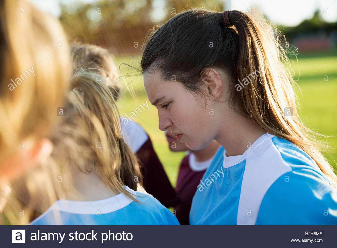 Attentive Middle School Girl Soccer Player Listening In Huddle