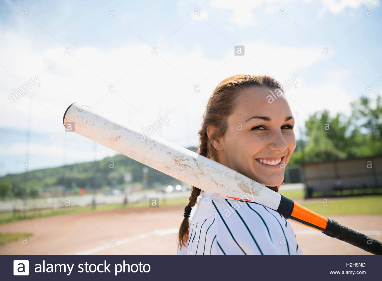 Portrait smiling middle school girl softball player holding bat Stock