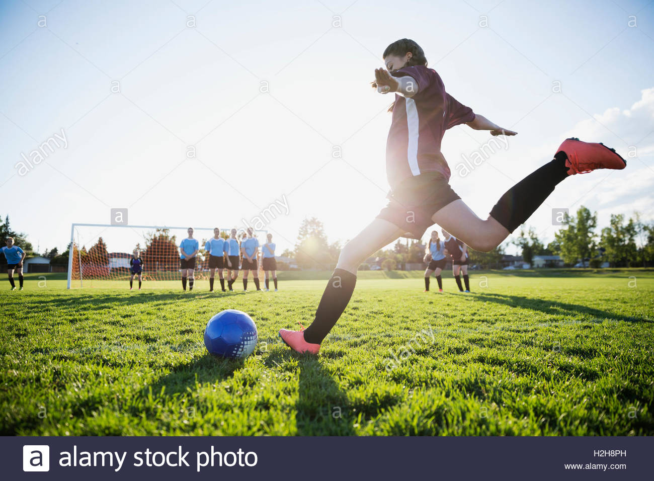 Child kicking ball into soccer net hires stock photography and images