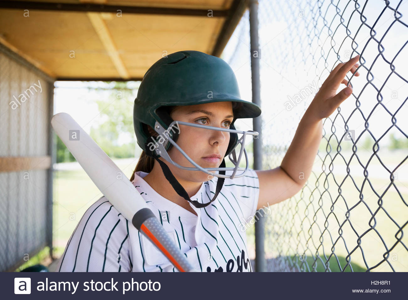 Serious middle school girl softball player wearing batting helmet and