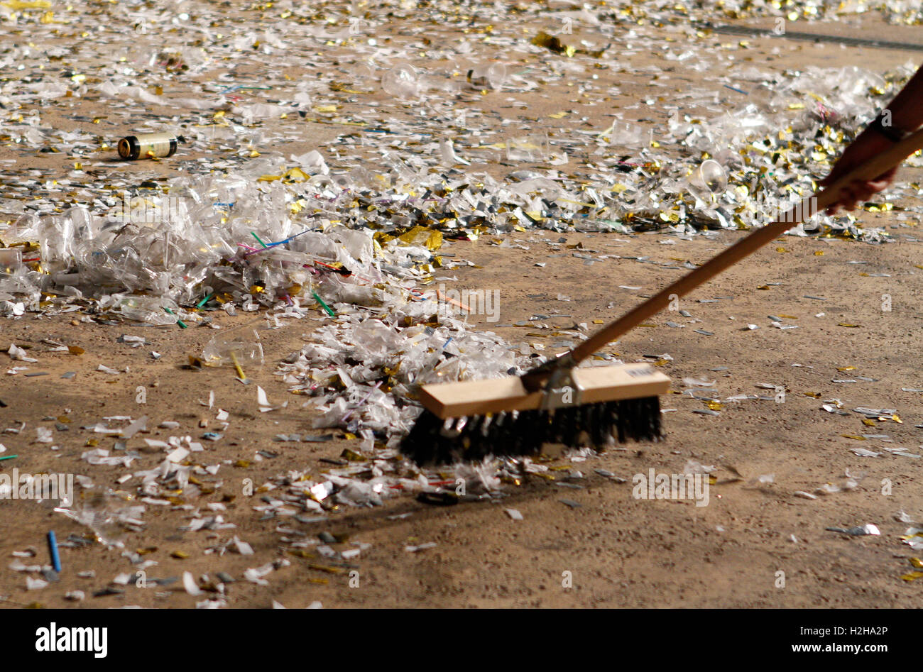 Person sweeping the dirty floor after a concert at night in Majorca